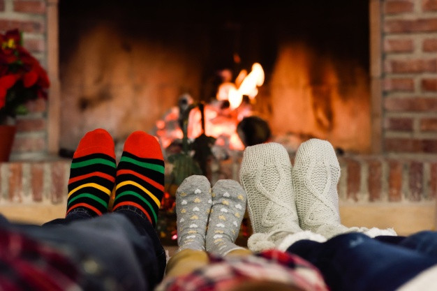 Christmas Sock Fireplace
 Feet in christmas socks near fireplace relaxing at home