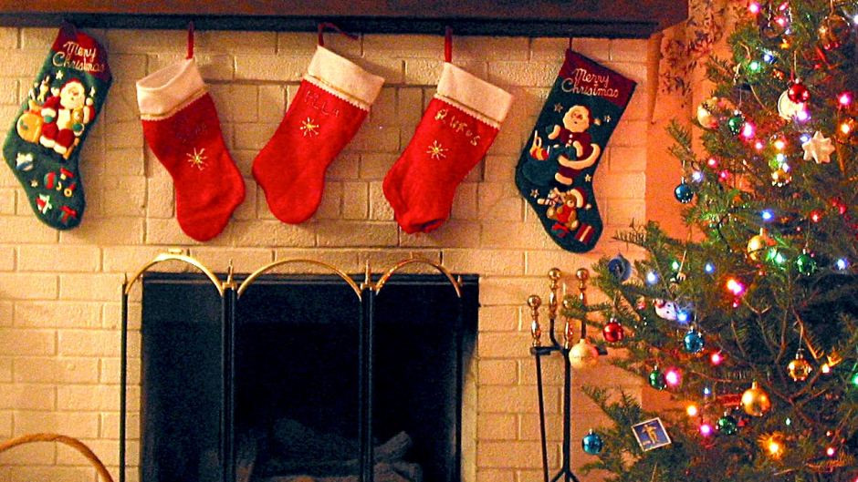 Christmas Stockings Hanging Over Fireplace
 Stockings hang above a fireplace next to a Christmas tree